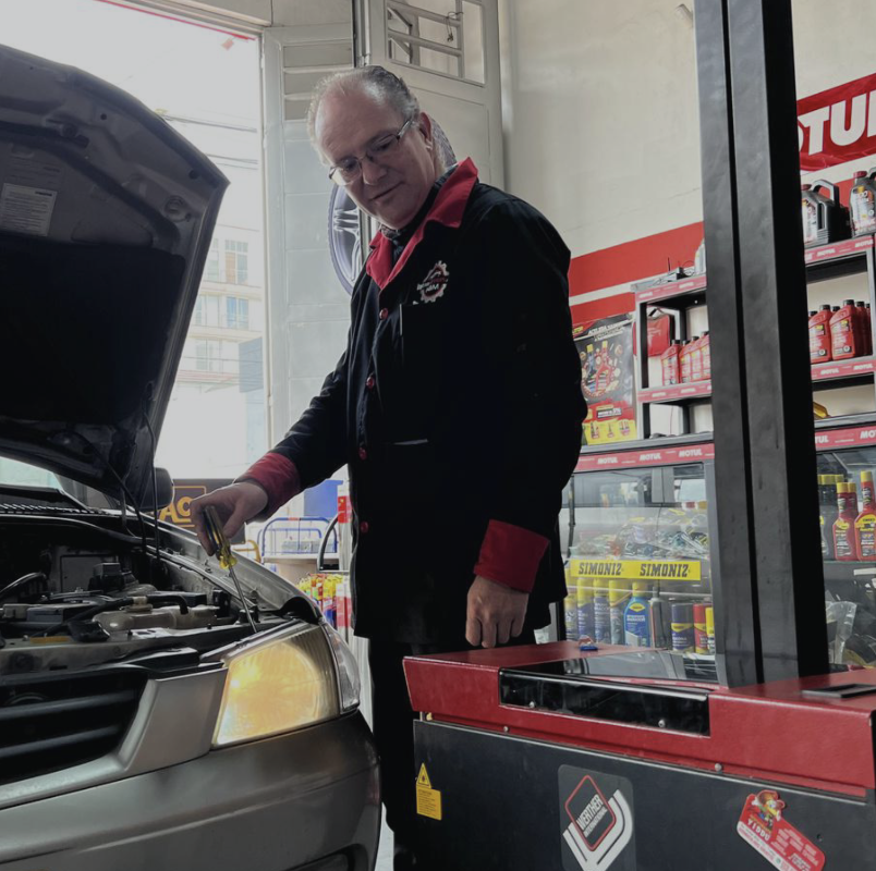 Técnico de Car Services H&M revisando el motor de un vehículo